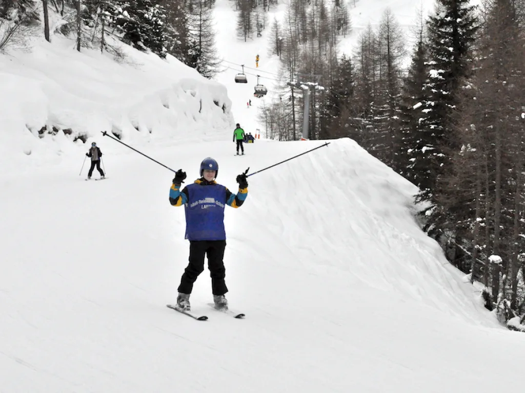Person breitet auf der Piste die Arme aus.